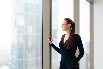 beautiful girl business lady in her office in a skyscraper