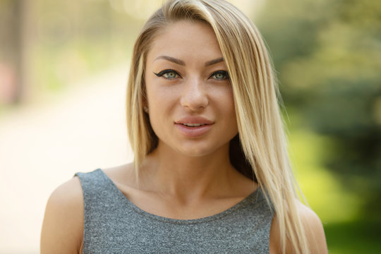 Beautiful smiling girl outdoor. A portrait of a beautiful blonde young Caucasian woman outdoor. 