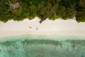 Aerial drone view of a deserted tropical island with beach and shallow coral reef (Stewart Island, Mergui Archipelago, Myanmar)