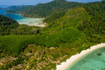 Fototapeta na wymiar Aerial drone view of a small fishing village on a lush, green tropical island