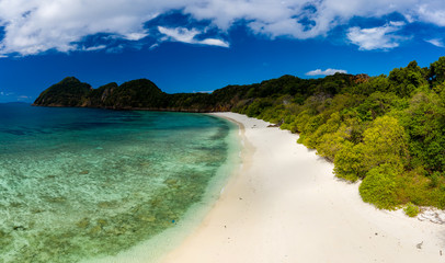 Fototapeta premium Aerial drone view of a deserted tropical island with beach and shallow coral reef (Stewart Island, Mergui Archipelago, Myanmar)