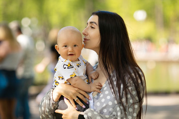 Mother and child laughing and playing in the summer on the nature background 