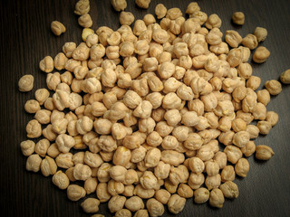 Close up of dried cheakpea beans (Cicer arietinum) on wooden background.