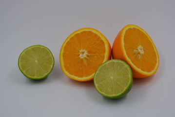 Bright two orange halves of sliced ​​ripe and juicy orange with lime fruits. Healthy food and...