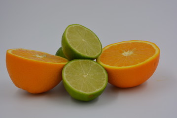 Bright two orange halves of sliced ​​ripe and juicy orange with lime fruits. Healthy food and...
