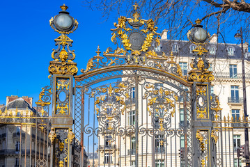     Paris, the beautiful parc Monceau, the golden wrought iron grid, with typical buildings in...