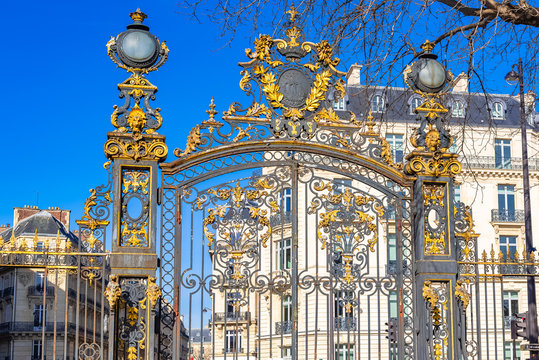     Paris, the beautiful parc Monceau, the golden wrought iron grid, with typical buildings in background 