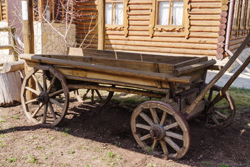 Fototapeta na wymiar Old wooden horse carriage. Orenburg, Russia - April, 22, 2019: Horse-drawn carriage in the courtyard of a village house
