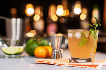 Fresh cocktail with lime, mint and ice on the background of the bar.