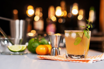 Fresh cocktail with lime, mint and ice on the background of the bar.