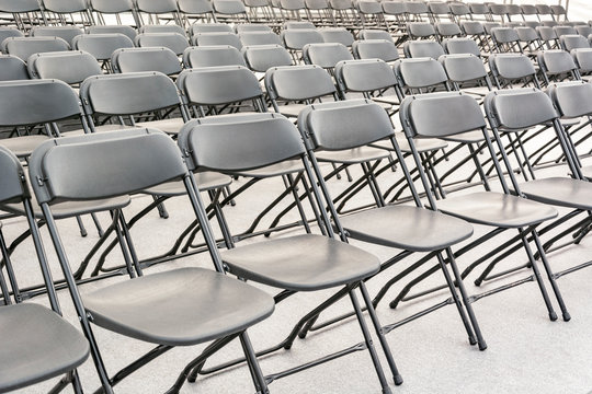 Rows of black folding chairs empty