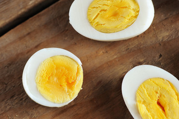 halves of boiled eggs on a wooden rustic background