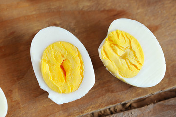 half of the eggs with the yellow yolk on wooden background