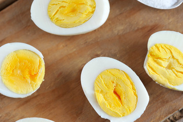 half of the eggs with the yellow yolk on wooden background