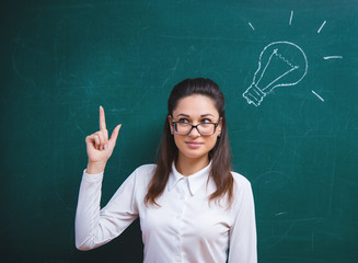 young woman thinks next to the board