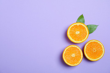 Flat lay composition with oranges and leaves on color background. Space for text