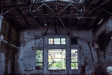 Fototapeta na wymiar Abandoned industrial creepy warehouse inside with big broken window, old dark grunge factory building