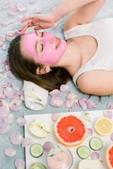Obraz na płótnie Canvas cosmetic procedures, mask for skin care, woman young, spa salon. Close-up portrait of beautiful girl lying on the bed in spa salon applying pink mud facial mask