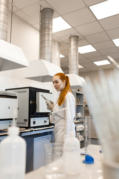 A young girl works in a laboratory. Girl researcher in a modern laboratory. The photo illustrates science and education.