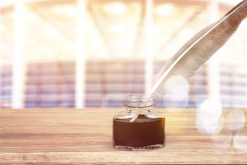 Feather quill pen and glass inkwell isolated on a white background