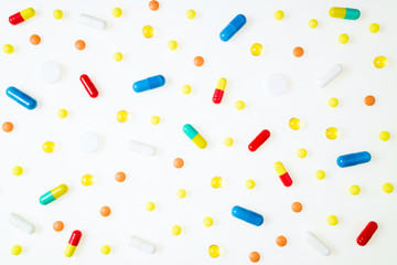 Assorted pharmaceutical medicine pills, tablets and capsules on white background top view. Medical background. Flat lay