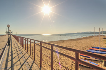 Naklejka premium view from the promenade to the pier on the sandy beach and the sea in .