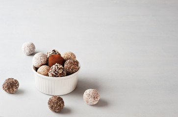 Energy balls in the white plate on the gray background.