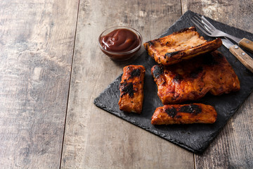 Grilled barbecue ribs on wooden table. Copyspace