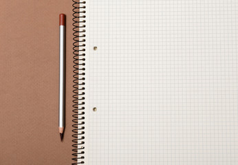 white checked notebook and gray pencil closeup