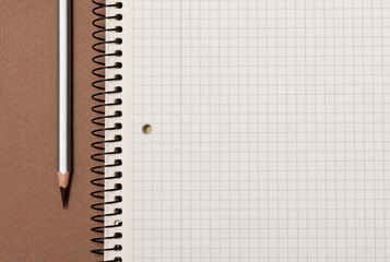 white checked notebook and gray pencil closeup