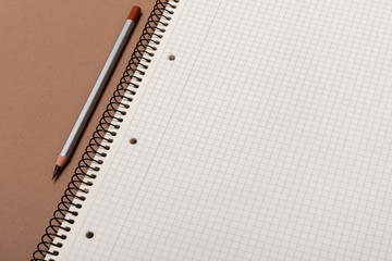 white checked notebook and gray pencil closeup