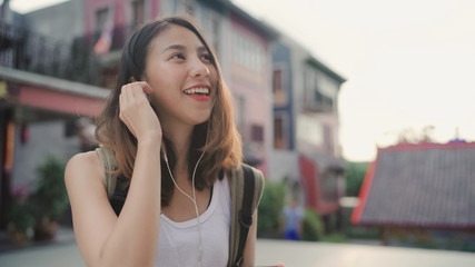 Asian backpacker blogger woman using smartphone for chat, check social media and listen to music while traveling at Chinatown in Beijing, China. Lifestyle backpack tourist travel holiday concept.