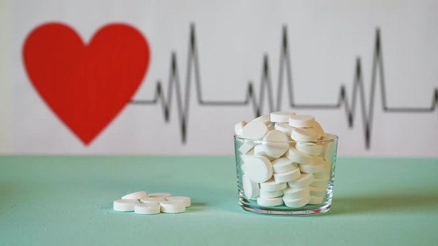 Tablets on the background of the cardiogram of the heart. Helthy heart concept. Time laps