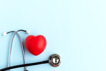Directly Above Stethoscope And Heart Shape on Blue Background - Medical and Insurance Concepts
