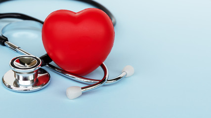 Stethoscope And Heart Shape on Blue Background - Medical and Insurance Concepts