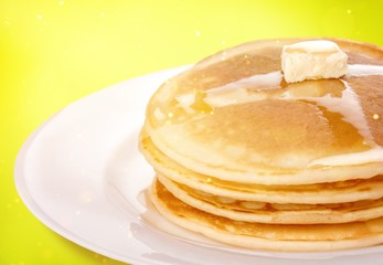 Stack of tasty pancakes with butter on a white plate