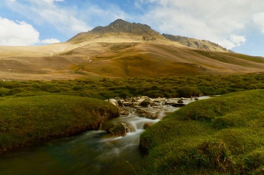 S stream flowing in front of a mountain in Kyrgyzstan 