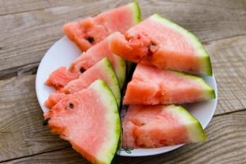 Sliced watermelon in a plate on wooden table