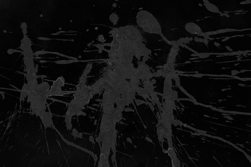 Black with gray paint splatter effect texture on gray paper background. Artistic backdrop. Different paint drops.