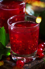 Red currant cocktail with juice, vodka and lime on dark table, top view