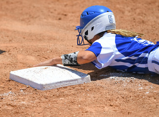 Young high school softball players in action, making amazing plays, during a game