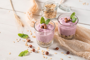 Healthy breakfast parfait with yogurt, granola and nuts in glass