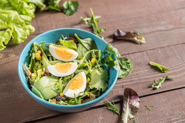Mixed vegetable salad with egg on rustic background