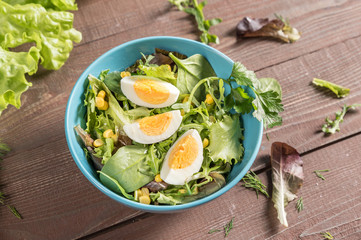 Mixed vegetable salad with egg on rustic background