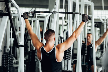 portrait of sporty girl workout on exercise machine in gym. Pretty young man training in the gym