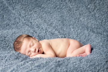 Obraz na płótnie Canvas Newborn Baby Sleeping on Textured Blanket