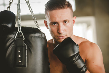 young strong sports man boxer make exercises in gym