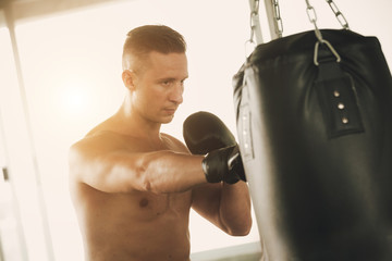young strong sports man boxer make exercises in gym