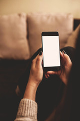 Holding a smartphone with blank screen.