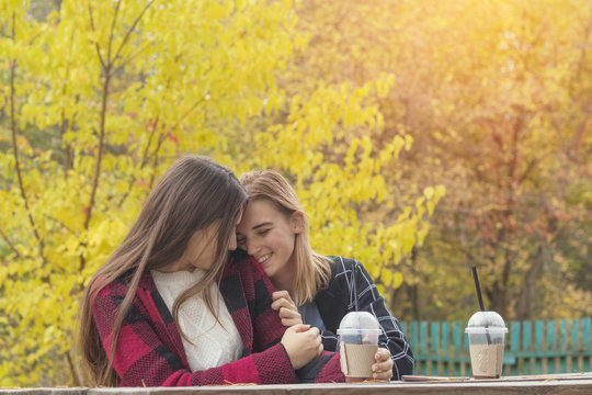 Two cute beautiful young women having conversation in park